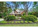 Two-story brick home with lush landscaping including a fountain, enhancing its curb appeal at 5718 Bardsey Ct, Matthews, NC 28104