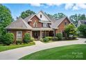 Charming two-story brick home featuring a covered front porch and well-manicured landscaping at 5718 Bardsey Ct, Matthews, NC 28104