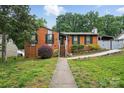 Traditional brick home with walkway to front door, surrounded by lush landscaping at 6221 Thermal Rd, Charlotte, NC 28211