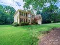 Picturesque home exterior featuring brick facade, lush landscaping, and a large yard at 7006 Olde Sycamore Dr, Mint Hill, NC 28227