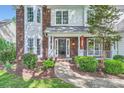 Charming brick home featuring a cozy front porch with a decorative wreath on the front door at 7600 Ridgefield Dr, Charlotte, NC 28269