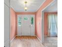 Bright foyer with hardwood floors, a white front door, and light peach-painted walls at 8017 Prince George Rd, Charlotte, NC 28210