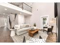 Inviting living room features a two-story ceiling, natural light and modern furnishings at 9527 Walkers Ferry Rd, Charlotte, NC 28214