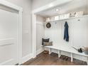 Bright mudroom with built-in bench, storage shelves, white wainscoting, and wood flooring at 9527 Walkers Ferry Rd, Charlotte, NC 28214