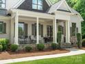 Inviting front porch with stone accents, a seating area and neutral paint color at 1007 Wessington Manor Ln, Fort Mill, SC 29715