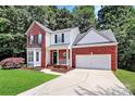 Charming two-story brick home featuring a bay window, manicured lawn, and an attached two-car garage at 101 Creekside Dr, Fort Mill, SC 29715