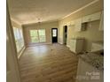 Well-lit kitchen with white cabinets, granite countertops, and new floors with abundant sunlight streaming through the windows at 1016 Old Thompson Ave, Lancaster, SC 29720