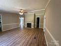 Spacious living room featuring wood flooring, a ceiling fan, and a cozy fireplace for comfortable living at 1016 Old Thompson Ave, Lancaster, SC 29720