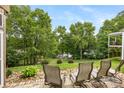 Inviting back patio features a lovely lawn and mature trees overlooking the serene waterfront at 10452 Quiet Bay Ct, Charlotte, NC 28278