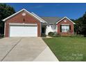 Charming single-story home with brick accents, a two-car garage, and a well-maintained lawn at 11332 Ridge Oak Dr, Charlotte, NC 28273