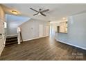 Open-concept living room with hard wood floors leading to stairs and white kitchen cabinets at 1176 Constitution Park Blvd, Rock Hill, SC 29732