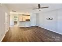 Open-concept living room with hard wood floors flowing into a kitchen with white cabinets and a ceiling fan at 1176 Constitution Park Blvd, Rock Hill, SC 29732
