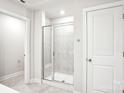 A clean, tiled bathroom with a glass-enclosed shower featuring a built-in seat and modern fixtures at 119 Obadiah Ct, Mooresville, NC 28115
