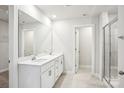 A modern bathroom featuring double sinks, a large mirror, white cabinets, and a glass-enclosed shower at 119 Obadiah Ct, Mooresville, NC 28115