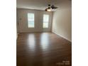 Bright living room with wood-look floors, two windows, and neutral paint at 135 Locomotive Ln # 106, Mooresville, NC 28115