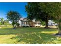 Well-maintained home on a spacious lot, framed by mature trees and lush green lawn at 1560 Springlake Rd, York, SC 29745