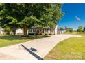 Expansive lot with a well-manicured lawn, mature tree, and driveway leading to the home and outbuildings at 1560 Springlake Rd, York, SC 29745