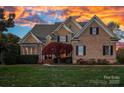Charming brick home with manicured lawn and mature tree, offering curb appeal and a welcoming entrance at 18823 Peninsula Cove Ln, Cornelius, NC 28031
