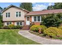 Beautifully landscaped front yard with walkway leading to a charming brick and siding home at 206 Cedarwood Dr, Salisbury, NC 28147