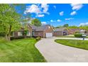 Well-maintained home with a winding driveway, attached garage, and lush green lawn at 229 River Birch Cir, Mooresville, NC 28115