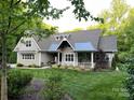 Beautifully landscaped yard with an inviting front porch and mature trees enhancing the home's curb appeal at 3201 Johnny Cake Ln, Charlotte, NC 28226