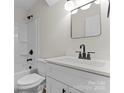 Bright bathroom featuring tub and shower combo, toilet, and vanity with black hardware at 3220 Riley Ave, Charlotte, NC 28269