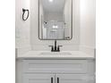 Bathroom with a black framed mirror hanging over a white vanity and black hardware at 3220 Riley Ave, Charlotte, NC 28269