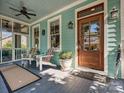 Inviting front porch featuring a wooden door, colorful chairs, and tranquil decor at 332 Delburg St, Davidson, NC 28036