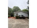 Well-maintained single-story home with wood steps and landscaped front yard creates a welcoming curb appeal at 400 Archibald Rd, Concord, NC 28025