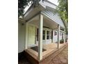Cozy front porch with brick base, white columns and bay window offers a welcoming entrance to the home at 400 Archibald Rd, Concord, NC 28025