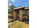 Arched glass doors to a brick building with grass yard in front and clear skies above at 415 Orchard Trace Ln # 8, Charlotte, NC 28213