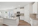 Modern kitchen boasts white cabinets, stainless steel appliances, and a large center island at 432 Bent Burr Crk, York, SC 29745