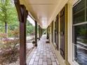 Long covered front porch with stone flooring, wood columns, and charming decorative accents at 4711 Truscott Rd, Charlotte, NC 28226