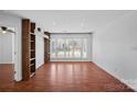 The open concept living room features hardwood floors, large windows, and custom built-in shelves at 513 N Graham St # 1B, Charlotte, NC 28202