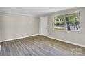 Spacious living room featuring neutral walls, new flooring, and a bright window at 5221 Wales St, Charlotte, NC 28269