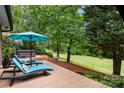 Relax on the deck with lounge chairs, umbrella, and a view of the expansive backyard at 54 Honeysuckle Woods, Clover, SC 29710