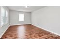 An airy bedroom featuring newly installed wood flooring, neutral paint, and ample natural light at 6517 Paleface Pl, Charlotte, NC 28214