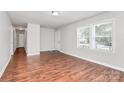 Bright living room featuring freshly painted walls, new wood flooring, and multiple windows at 6517 Paleface Pl, Charlotte, NC 28214