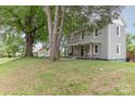 Traditional two-story home with covered front porch, mature trees, and a well-maintained lawn at 702 S Government St, Lincolnton, NC 28092