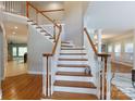 A traditional staircase with white spindles, hardwood steps, and a landing showcasing the home's interior design at 905 Patricians Ln, Monroe, NC 28110