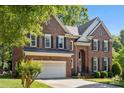 Beautiful two-story brick home with attached two-car garage and manicured landscaping at 909 Staghorn Ln, Waxhaw, NC 28173