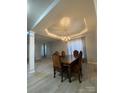 Elegant dining room with a large wooden table, a chandelier, and a view of the outside at 10901 Claude Freeman Dr, Charlotte, NC 28262