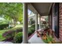 Inviting front porch featuring classic columns, comfortable seating, and lush landscaping, perfect for relaxing outdoors at 1108 Longwood Ct, Matthews, NC 28104