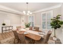 Bright dining room with shutters, table, and six chairs, showcasing modern design and comfort at 113 Callandor Ct, Troutman, NC 28166