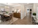 Elegant dining room with hardwood floors, modern lighting, wainscoting, and neutral decor at 113 Callandor Ct, Troutman, NC 28166
