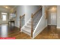Elegant staircase with dark wood banister and trim, carpeted steps, and hardwood landing at 146 Ventor Way, Mooresville, NC 28115
