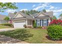 Charming home featuring a two-car garage, tidy lawn, and colorful landscaping on a sunny day at 2035 Moultrie Ct, Fort Mill, SC 29707
