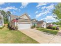 Charming home featuring a two-car garage, tidy lawn, and colorful landscaping on a sunny day at 2035 Moultrie Ct, Fort Mill, SC 29707
