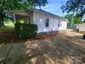 Side angle of home with a covered porch, tidy landscaping, and spacious driveway at 309 E 11Th St, Kannapolis, NC 28083