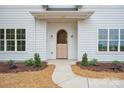 Charming wooden front door is framed by elegant sconces and manicured landscaping at 3622 E Brief Rd, Monroe, NC 28110